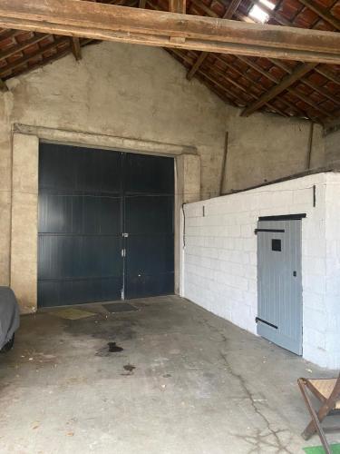 a garage with two large garage doors in a building at Maison aux portes de sologne in Vierzon
