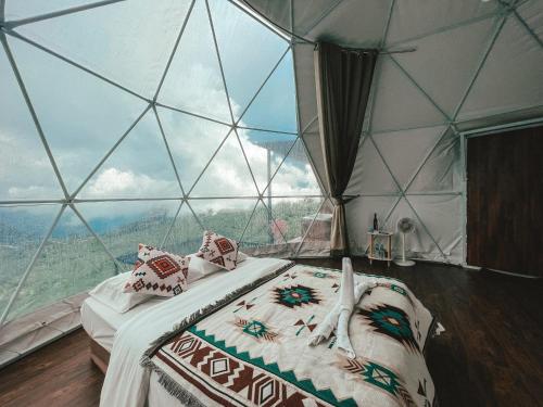 a bedroom with a bed in a glass dome at Tubburk glamping VIP in Ban Maeo Thap Boek