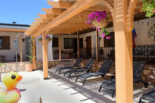 a row of chairs on a patio with a pergola at Hacienda Cabreras in Villena