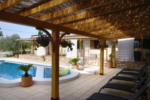 a patio with chairs and a swimming pool at Hacienda Cabreras in Villena