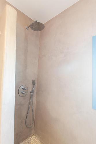 a shower in a bathroom with a shower head at Santorini Garden Homes in Mesaria