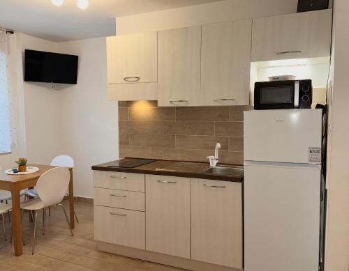 a kitchen with a white refrigerator and a table at Friedrich Apartments in Merano