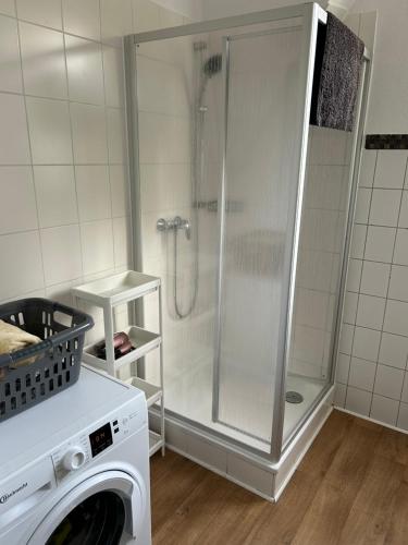 a washing machine in a bathroom with a shower at Zentral gelegene 3 Zimmerwohnung mit zwei Schlafzimmern ideal für Monteure in Bad Oeynhausen
