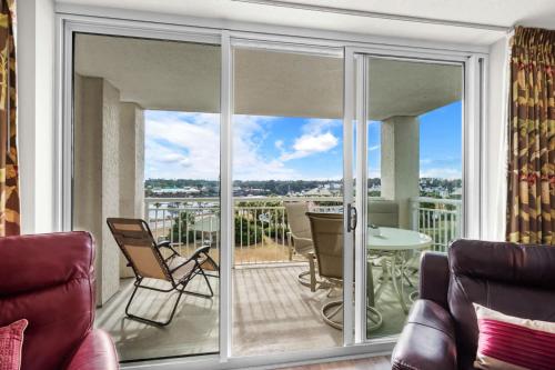 a living room with a balcony with sliding glass doors at Yacht Club Villas 1-505 - Marina View in Myrtle Beach