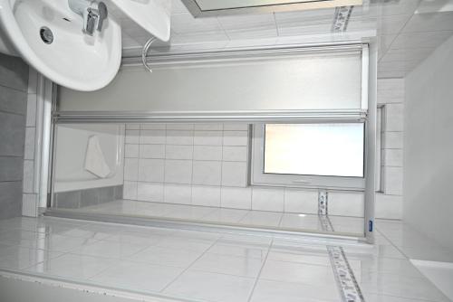 a bathroom with a sink and a window with a screen at Einzelzimmer-05-EG in Borkum