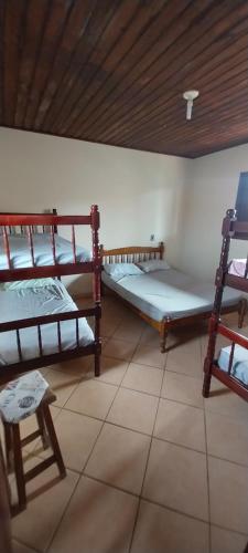 a room with three bunk beds and a wooden ceiling at Apartamento Ilha comprida centro in Ilha Comprida