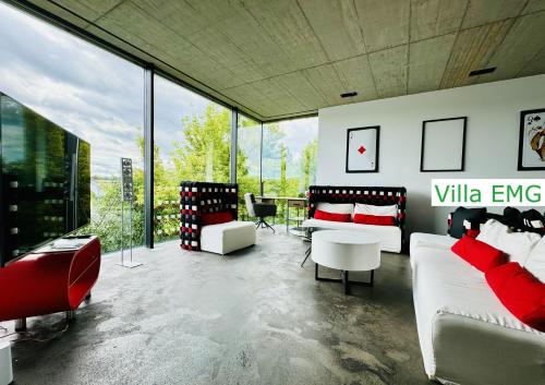 a living room with red and white furniture and large windows at Luxury Villa EMG Frankfurt Heidelberg - Bensheim in Bensheim