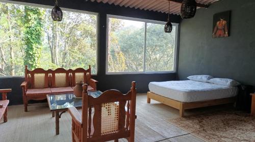 una camera da letto con un letto, un tavolo e finestre di Finca 7 Reyes Casa con alberca a Villa del Carbón