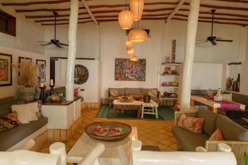 a living room with couches and a table at Posada & Spa La Ardileña en Morrocoy in La Luisa