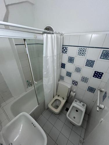a bathroom with a toilet and a tub and a sink at Exelente alojamiento in Buenos Aires
