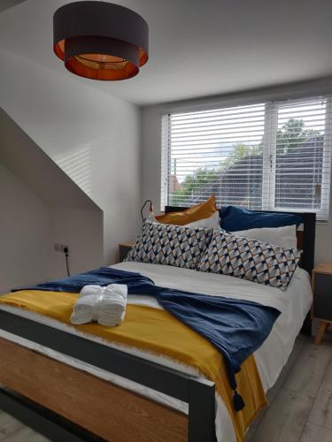 a bedroom with a large bed with yellow and blue sheets at 3 bed countryside cottage with use of private pool in Norwich