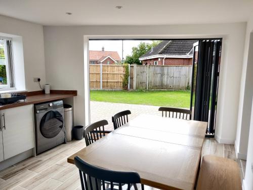 a kitchen and dining room with a table and chairs at 3 bed countryside cottage with use of private pool in Norwich