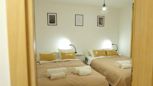 a mirror reflection of a bedroom with two beds at Apartman M-A-P in Bukovlje
