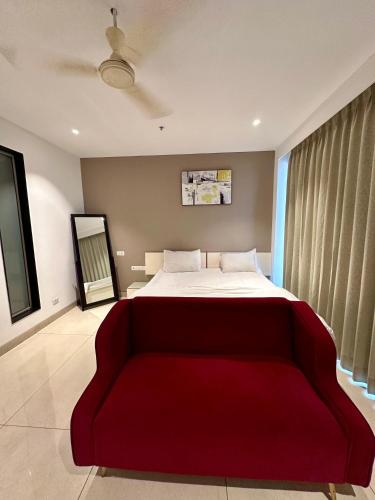a bedroom with a large bed and a red couch at Luxury Studios Key 4 in Gurgaon