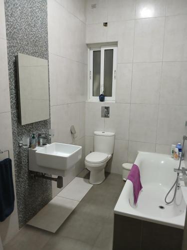 a bathroom with a sink and a toilet and a tub at Spacious 3 Bedroom Apt Near the Sea in St Paul's Bay