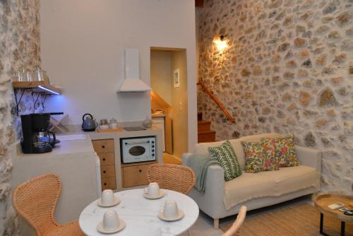 a living room with a couch and a table and chairs at Caeli's Home in Gythio