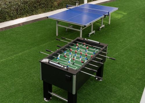 a ping pong table sitting on top of grass at Izzzi Life Mint in Dubai
