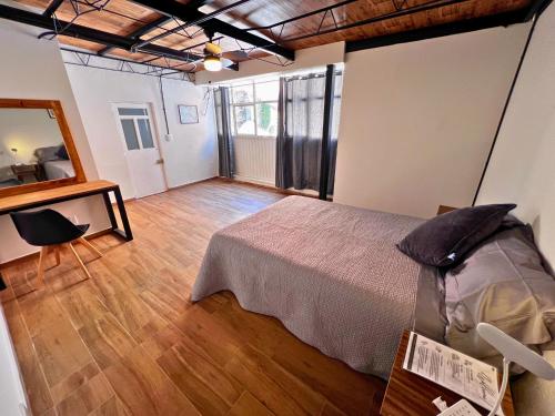a bedroom with a bed and a wooden floor at Discover Condesa Ideal Location in Mexico City