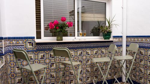 a group of chairs sitting in front of a window at Palacete BARSANZ HOME in Alcalá del Valle