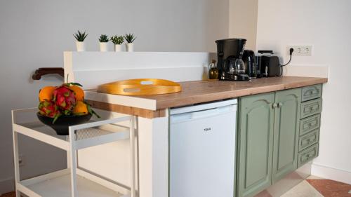 a kitchen with green cabinets and a wooden counter top at Palacete BARSANZ HOME in Alcalá del Valle