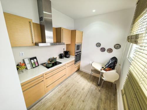 a kitchen with white counters and wooden cabinets at Palacete BARSANZ HOME in Alcalá del Valle