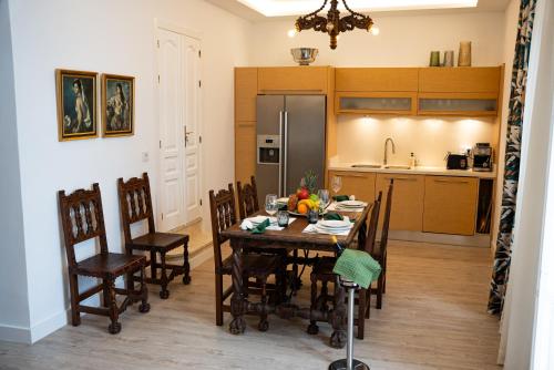 a kitchen with a table with chairs and a refrigerator at Palacete BARSANZ HOME in Alcalá del Valle