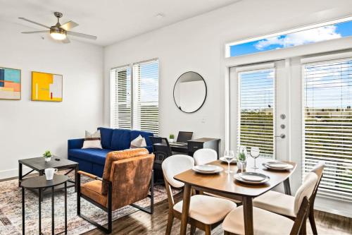 a living room with a blue couch and a table at Luxurious New Unit 1Bd1Ba Pool Golf Sim in Austin