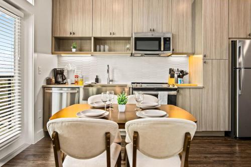 a kitchen with a wooden table with chairs and a dining room at Luxurious New Unit 1Bd1Ba Pool Golf Sim in Austin