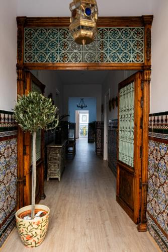 a hallway in a home with a potted plant at Palacete BARSANZ HOME in Alcalá del Valle