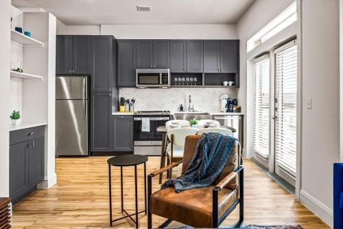 a kitchen with black cabinets and a table and chairs at Luxurious New Unit 1Bd1Ba Pool, Golf Sim in Austin