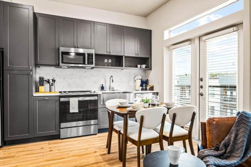 a kitchen with a table and chairs in a room at Luxurious New Unit 1Bd1Ba Pool, Golf Sim in Austin