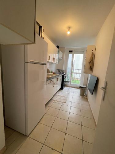 Il comprend une cuisine équipée d'un réfrigérateur blanc. dans l'établissement Appartement situé à Villejuif à 5 minutes du métro ligne 14, à Villejuif