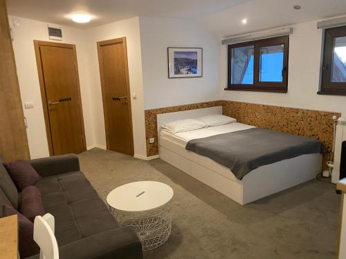 um quarto com uma cama e um sofá em Vuk & Sofija Apartmani em Kopaonik