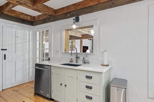 a kitchen with white cabinets and a sink at Modern Lux Cabin w Mtn Views and Fire Pit in Stratton