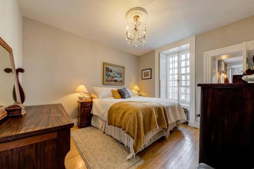 a bedroom with a bed and a table and a chandelier at 2002 Les Immeubles Charlevoix - 2002 - Le Parloir in Quebec City