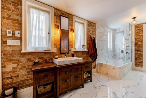 a bathroom with a sink and a shower and a tub at 2002 Les Immeubles Charlevoix - 2002 - Le Parloir in Quebec City