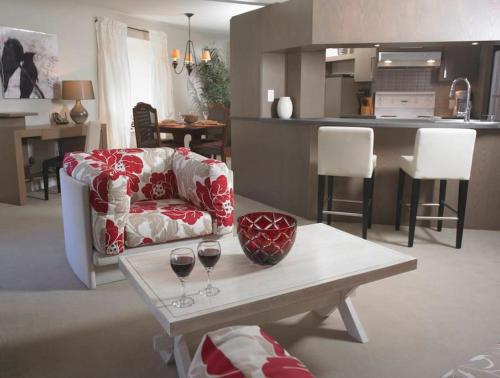 Una sala de estar con un sofá y una mesa con copas de vino. en 1003 Les Immeubles Charlevoix - 1003, en Quebec