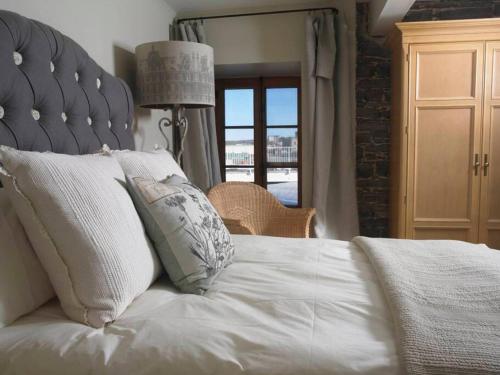 Un dormitorio con una cama grande con sábanas y almohadas blancas. en 1003 Les Immeubles Charlevoix - 1003, en Quebec