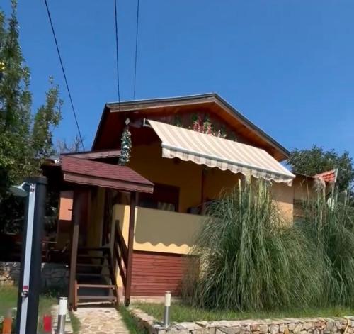 a small house with a porch and stairs to it at Sunshine villa Dzhigurovo in Sandanski
