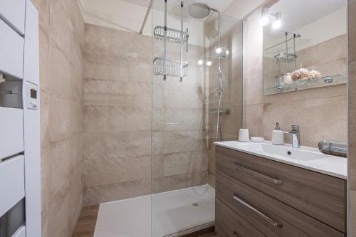 une salle de bain avec un lavabo et une douche dans l'établissement RIVIERA PRESTIGE - Appartement calme à 50m de la plage avec terrasse et parking, à Roquebrune-Cap-Martin