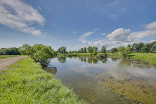 a river next to a dirt road next to a field at Stunning Sheridan Ranch Villa Mountain View! in Sheridan