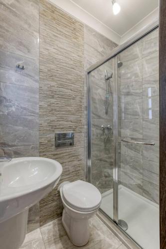 a bathroom with a sink and a toilet and a shower at Penthouse, Seaview, Beautiful 2br Apt 4 in Marsaskala
