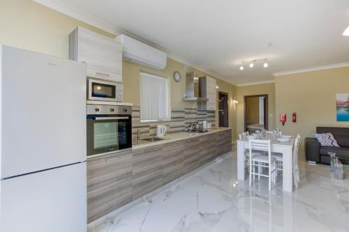 a kitchen and living room with a refrigerator and a table at Penthouse, Seaview, Beautiful 2br Apt 4 in Marsaskala