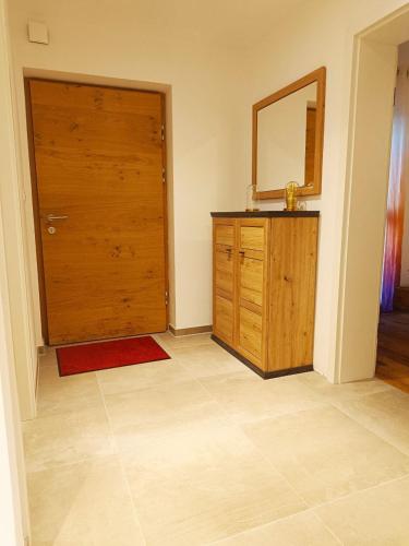 a bathroom with a wooden door and a mirror at Neue und sonnige Doppelhaushälfte in Dobl bei Graz Top 2 in Dobl