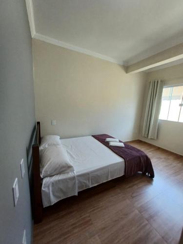 Un dormitorio con una cama y una ventana grande. en Pousada Estrela Mares Suíte 210, en Cabo Frío