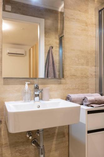 a bathroom with a white sink and a mirror at Beautiful Modern Central 2BR Apt in Taʼ Xbiex