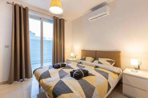 a bedroom with a bed with two bags on it at Beautiful Modern Central 2BR Apt in Taʼ Xbiex