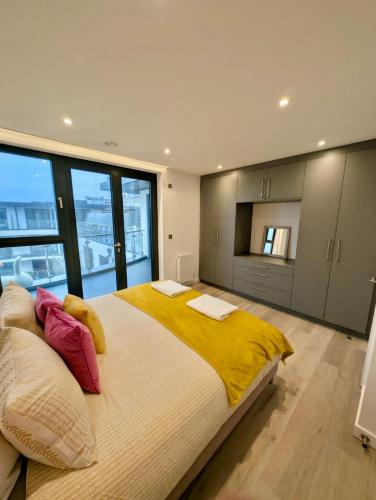 a bedroom with a large bed with yellow and red pillows at Ramsgate Stunning Penthouse With SeaViews And Free Parking in Ramsgate