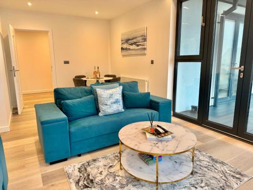 a living room with a blue couch and a table at Ramsgate Stunning Penthouse With SeaViews And Free Parking in Ramsgate