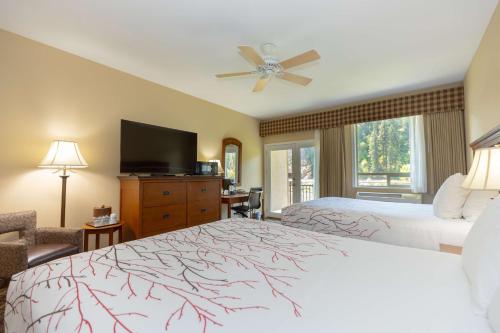 a hotel room with two beds and a flat screen tv at Best Western Lodge at River's Edge in Orofino